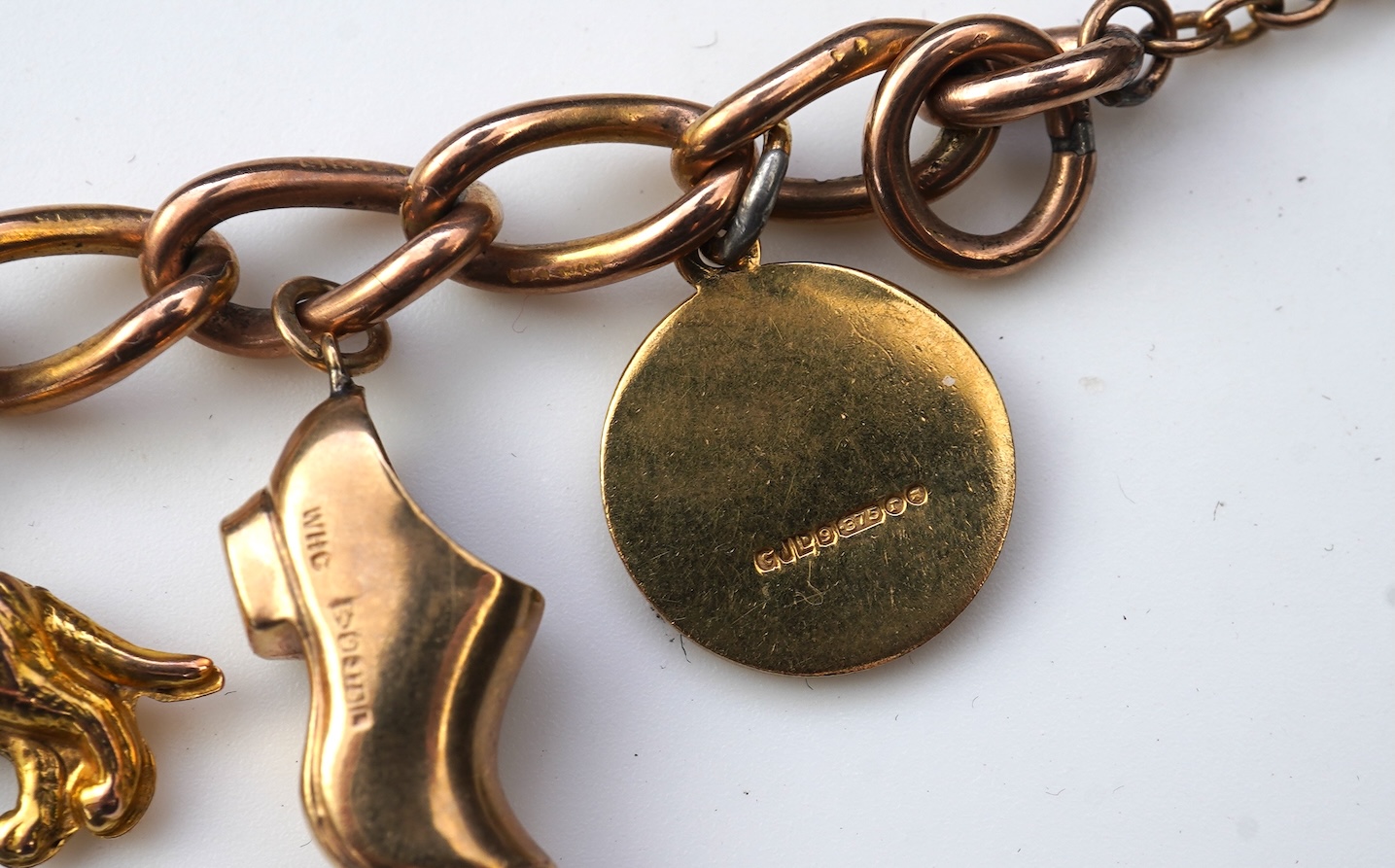 A gold charm bracelet, mid 20th century
